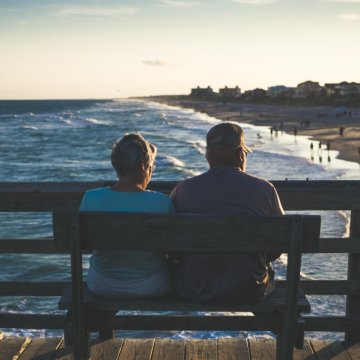 Couple sitting on a bench by the beach